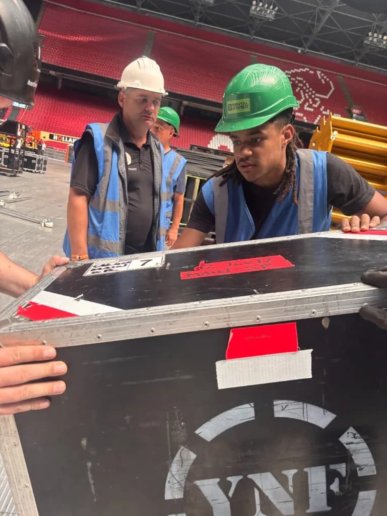 Helping Hands crew met flightcase in een stadion