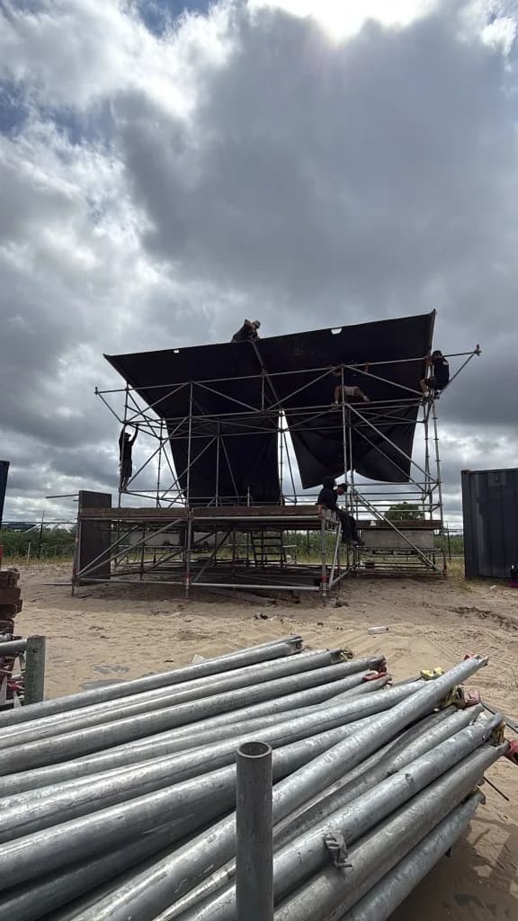 Helping Hands crew bouwt scaffolding op locatie