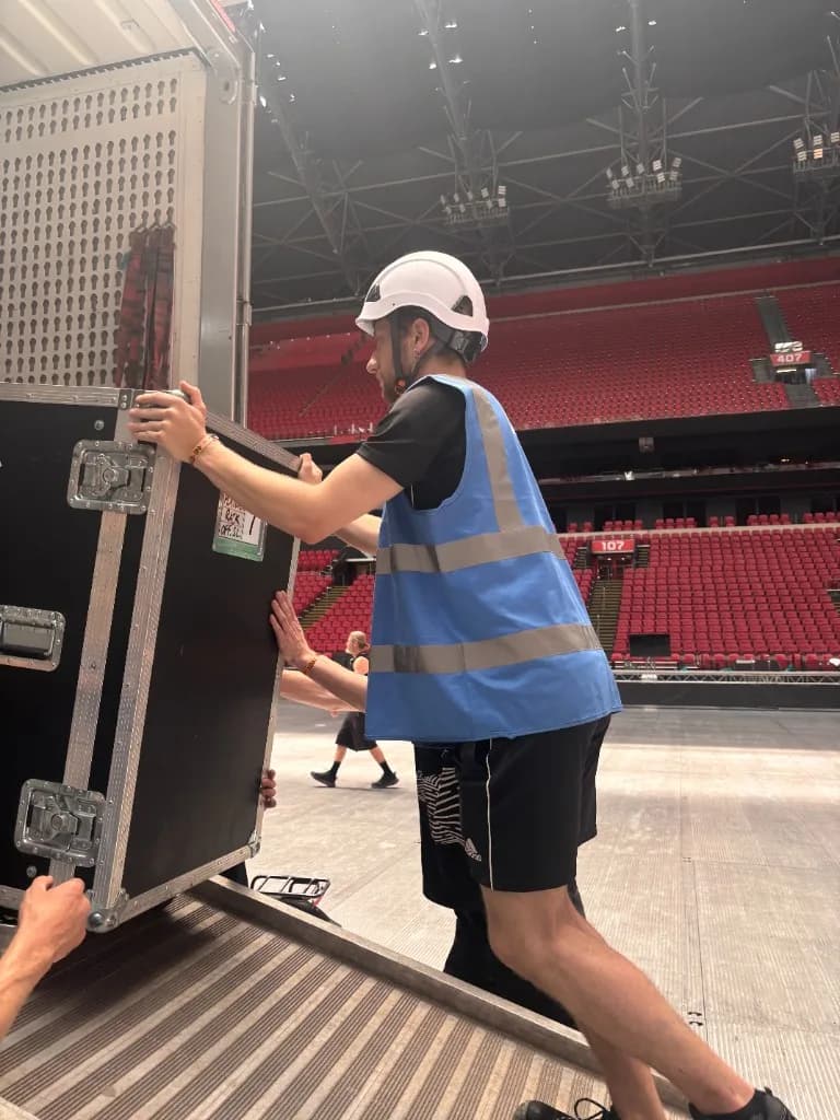 Eventcrew verplaatst flightcase in een stadion